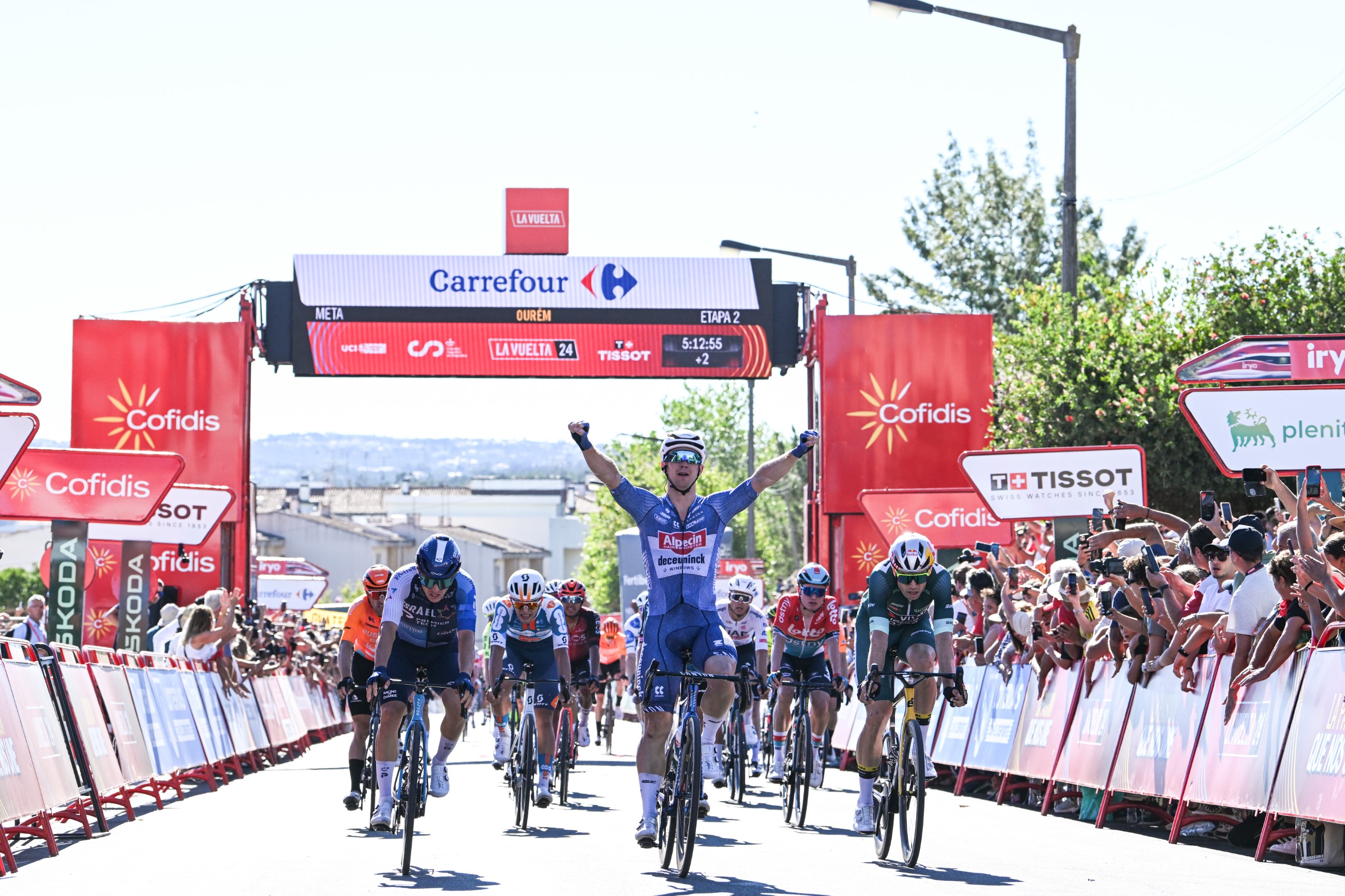 Australian road cycling sprinter Kaden Groves of Alpecin-Deceuninck winning stage 2 of the 2024 Vuelta a Espana in Portugal, with his arms in the air in celebration ahead of the bunch sprint